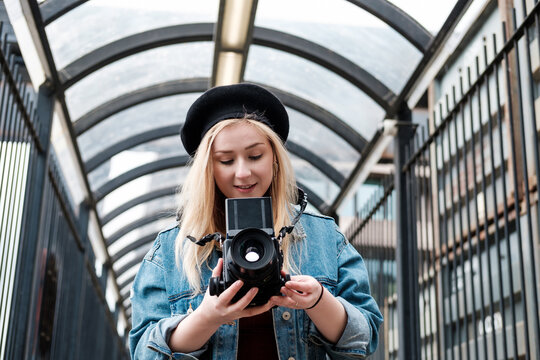 Young woman taking pictures with a film camera.