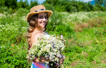 Small girl collecting flowers and herbs on sunny day, vacation concept