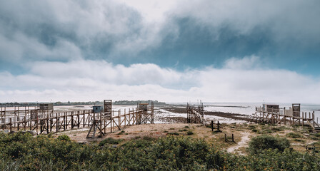 Typical old wooden fishing huts on stilts, called "carrelet", in the atlantic ocean near La Rochelle, France  © mathilde