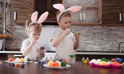 happy Easter. funny kids boy and girl with bunny ears play, prepare for the holiday and paint eggs.
