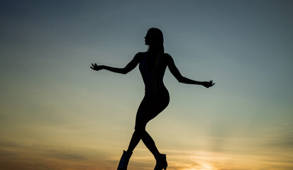 Fototapeta na wymiar perfect female body. sensuality. female silhouette on sunset. woman dance in dark.