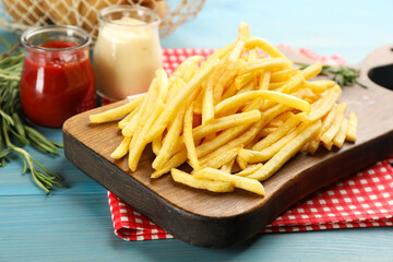 Delicious french fries served on blue wooden table