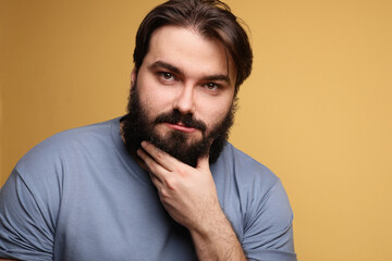 Obraz premium Big young man with beard, posing over yellow background. Isolated.