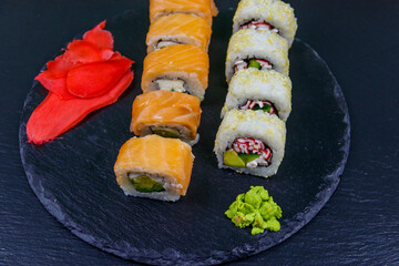 Set of sushi rolls on a black stone slate