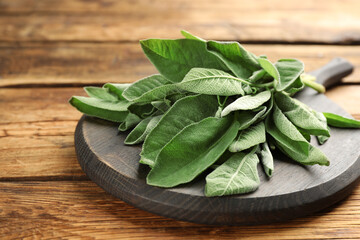 Bunch of fresh sage leaves on wooden table, closeup