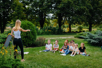 A teacher teaches a class of children in an outdoor Park. Back to school, learning during the pandemic