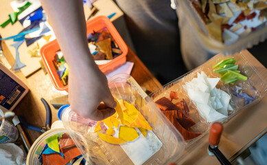selecting pieces of colored glass for a stained glass window