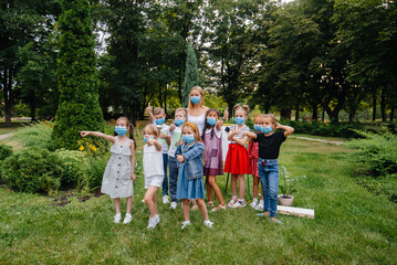 Obraz premium A class of masked school children is engaged in outdoor training during the epidemic. Back to school, learning during the pandemic