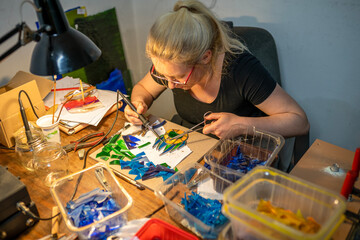 soldering the stained glass window, woman is making a stained glass, soldering the stained glass window - obrazy, fototapety, plakaty