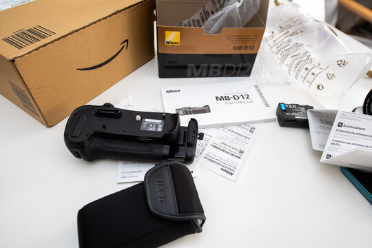 Paris, France - FEb 5, 2018: View from above of the unboxing process of new Nikon MB-12 camera grip delivered by Amazon Japan