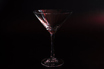Empty Glass Clear Martini Glass with Red Tint on Black Background