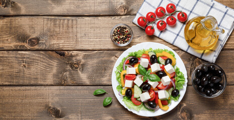 Obraz na płótnie Canvas Healthy Greek Vegetables Salad with cheese on wooden background. Healthy food with fresh vegetables for dinner. Mediterranean cuisine. Top view, flat lay, banner, copy space