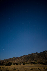 Obraz na płótnie Canvas Night Sky Over Moonlit Desert