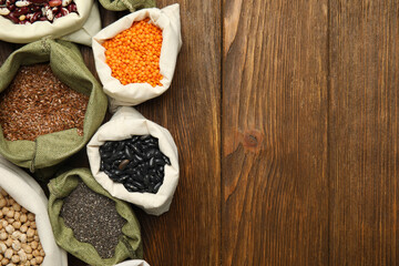 Different grains, seeds and space for text on wooden table, flat lay. Veggie diet