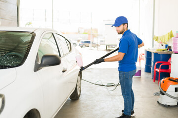 Latin man busy at the auto detail service