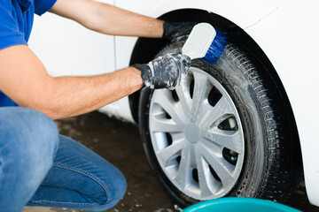 Hispanic male worker washing the car tires © AntonioDiaz