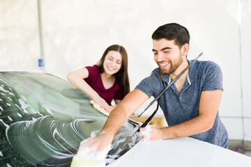 Couple in love washing their car together