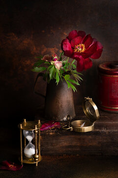 Red Peonies with sand hourglass and an old compass 