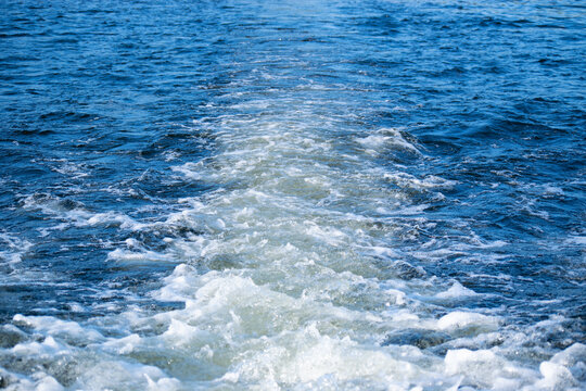 Aqua blue lake water with waves from pontoon boat.  White waves in beautiful blue lake water.