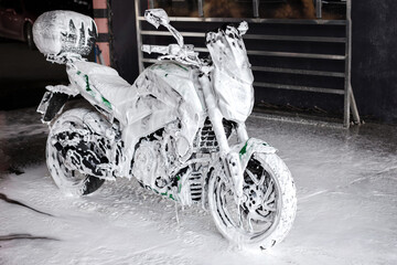 street motorcycle in soap at the car wash washes