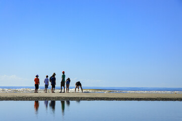 Silhouette of a family on a beach.with clear blue sky and reflection.