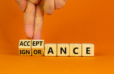 Acceptance or ignorance symbol. Businessman turns cubes, changes the word 'ignorance' to 'acceptance'. Beautiful orange table, orange background. Business, acceptance or ignorance concept. Copy space.