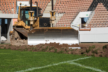  A bulldozer removes turf on a soccer field. © Dziurek
