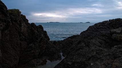 Mer entre deux rochers sous un ciel gris
