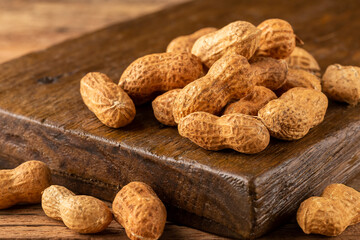 Dry peanut on the wooden background.