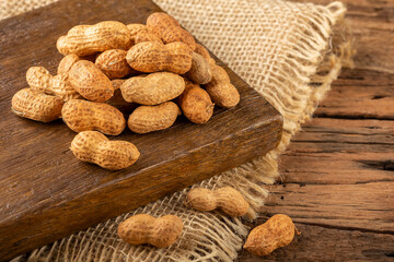 Dry peanut on the wooden background.