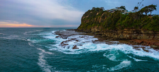 Aerial sunrise seascape panorama with rock platform and cloud cover