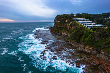 Aerial sunrise seascape and rock platform with cloud cover