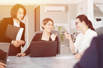 Three young successful business women in the office, together, happily working on a project