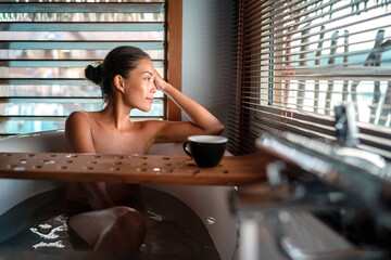 Luxury bath Asian woman relaxing in warm water enjoying view from bathroom window lying in bathtub...