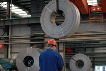 Workers are busy on the strip production line in an iron and steel company.