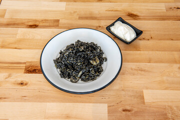 Enameled plate with portion of black rice with squid