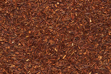 Rooibos tea texture close up. Dry redbush healthy tea, top view.