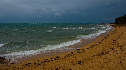Plage de Locmariaquer sous un ciel gris tempétueux 