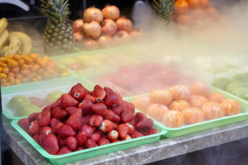 Chilled fruits on counter of grocery store.