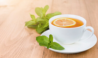tea with lemon and mint on a wooden table