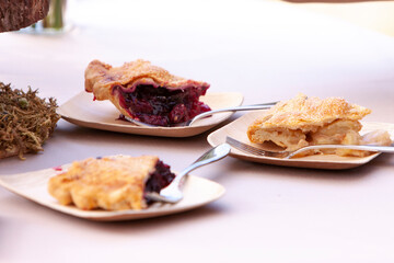 Three slices of pie on individual plates ready to be served, Cherry pie, apple pie, and berry pie.