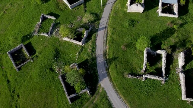 Ruined and damaged houses in village as war aftermath. Aerial drone view of homes destroyed and burned in war by artillery. Abandoned buildings. Houses ruins. 