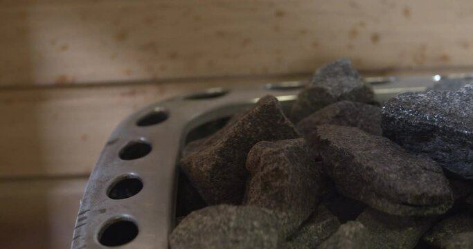 Pouring water on the rocks from a sauna heater. Water evaporated by hot stones