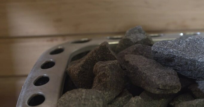 Closeup view with the pile of rocks on sauna heater. Trucking from left to right