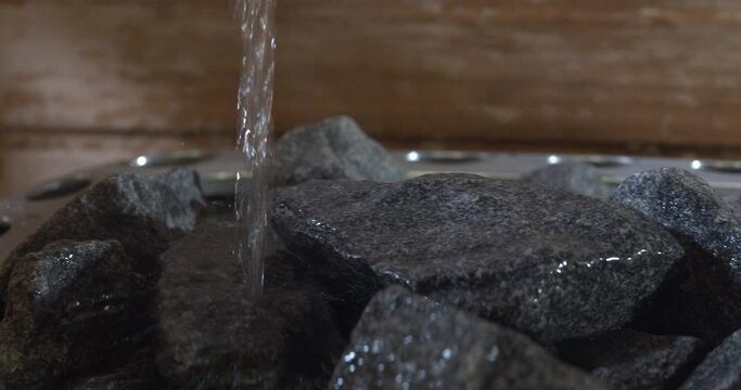 Igneous rocks on a sauna heater. Pouring water over the hot stones