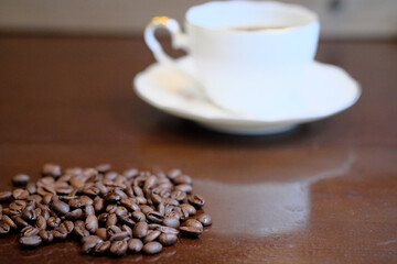 机に置かれたコーヒー豆とカップ