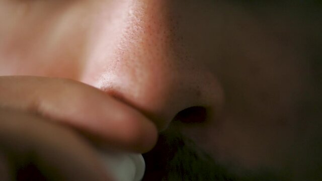 Man with a moustache adding nose spray- slow motion, close up shot