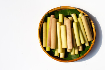 Lotus stems for cooking in bamboo basket on white