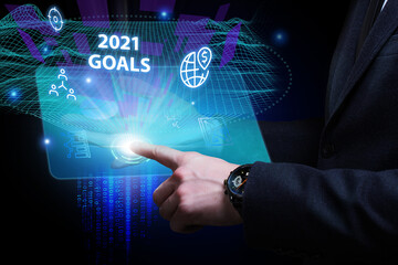 Business, Technology, Internet and network concept. Young businessman working on a virtual screen of the future and sees the inscription: 2021 goals