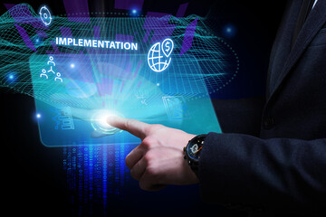 Business, Technology, Internet and network concept. Young businessman working on a virtual screen of the future and sees the inscription: Implementation